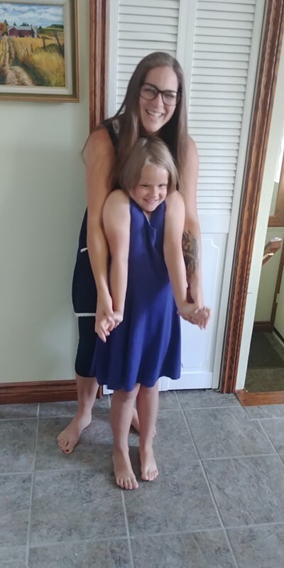 Mother and daughter wearing matching dark blue dresses. 